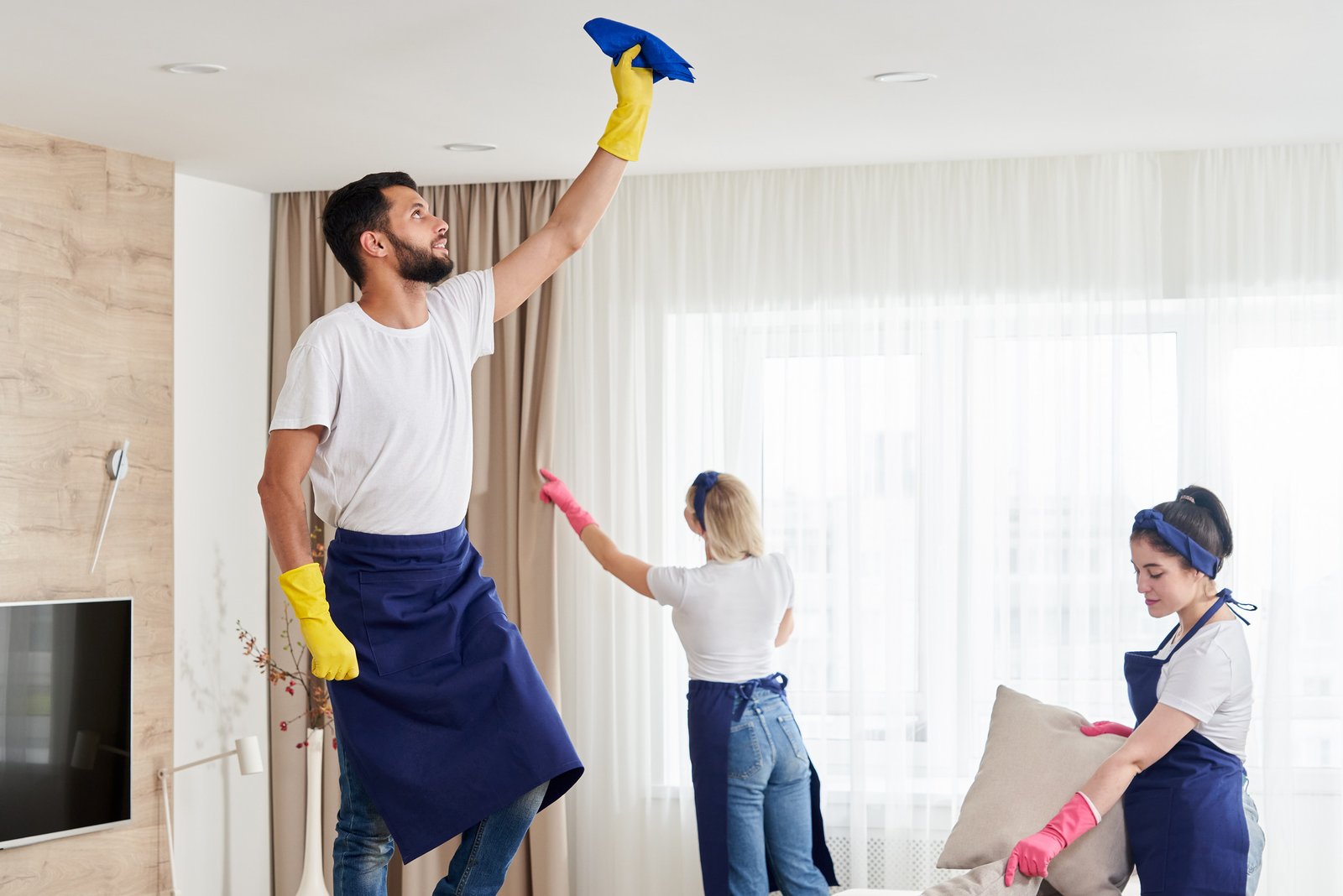 Professional cleaning service team cleans living room in modern apartment